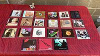 Array of compact discs laid out on quilted blanket, full group overview