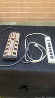 Both surge protectors side by side showing cords and overall condition