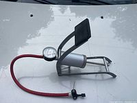 Full view of the foot pump showing frame, cylinder, hose and gauge