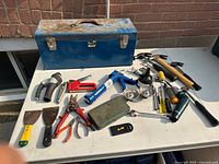 Overview of toolbox and spread out hand tools on table