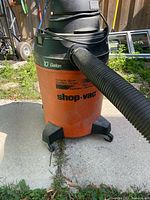 Front view of orange Shop-Vac with hose attached