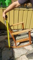 Side view of rocking chair with measuring tape indicating overall height