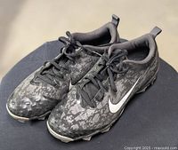 Top view of both cleats showing camouflage uppers, laces, white swoosh logos