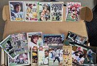 Sample of vintage football cards displayed on box lid showing different brands and eras