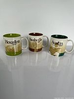 Front view of all three Starbucks city mugs