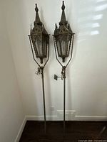 Full view of both brass processional lanterns on long poles