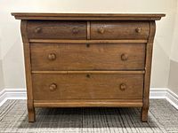 Front view of wooden four-drawer chest showing knobs and curved sides