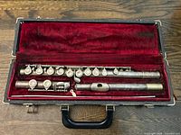 Open case displaying all three flute sections inside red velvet interior