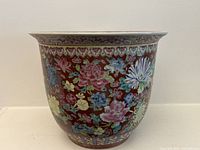 Full side view of ceramic jardiniere showing floral decoration and shape