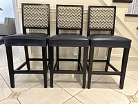 Front view of three matching barstools showing seats, backrests, frames
