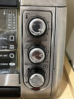 Control panel showing three rotary knobs and temperature scale