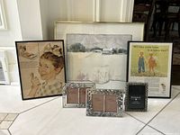 Group shot of framed watercolor, vintage ad prints, and photo frames