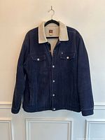 Front view of navy corduroy sherpa-lined jacket on hanger