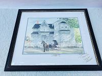 Full view of the framed print showing the horse and carriage in front of the Victorian style house with white picket fence and surrounding garden, dark wooden frame and matting.