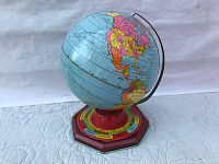 Full view of vintage 1930s tin litho globe showing North and South America, with a blue ocean and pastel-colored litho countries.