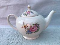 Front side view of the teapot showing floral design and overall shape.