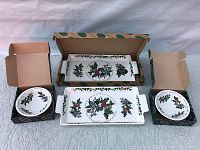 Four ceramic serveware pieces featuring The Holly and The Ivy design and original boxes in background.
