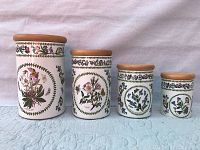 Full set of four vintage Portmeirion floral canisters with wooden lids aligned by size.