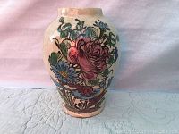 Front view of the Majolica vase showing blue and pink flowers with bird motifs.