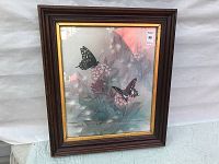 Full view of the framed print showing the butterflies and flower illustration with dark wooden frame and gold inner trim.