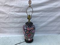 Full view of the vintage Chinese floral chintz table lamp showing the ceramic floral patterned base, brass socket, finial, and cord.