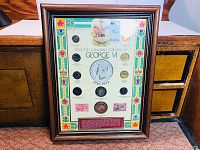 Frontal shot of wooden frame titled "Selected Canadian Coinage of George VI" with coins and stamps