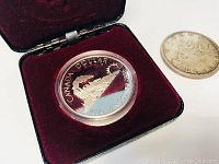 1986 Vancouver Canada Dollar silver coin in protective plastic case in a red velvet display box