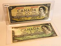 Front view of both banknotes in protective sleeves with label '1954' visible