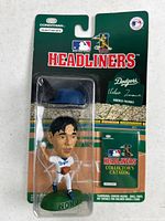 Front of sealed blister package showing figure, cap, catalog and branding