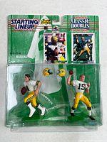 Front view showing sealed blister with both figures, helmets, and cards