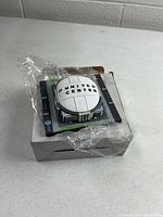 Model with roof on, sitting on box with plastic wrap