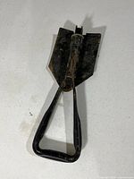 Shovel folded inward showing handle and blade