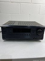Front view of Onkyo TX-SR604 receiver showing display, controls and volume knob