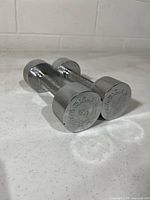Pair of chrome dumbbells angled on countertop