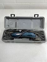 Sander stored inside gray plastic carry case