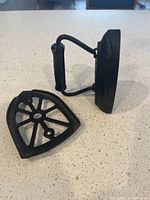 sad iron resting on side with trivet beside