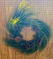 Full view of artificial pine wreath with pinecones