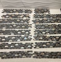 Grouped mosaic ceramic tile strips laid out to show quantity and style