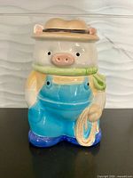 Front view of ceramic pig cookie jar with hat lid attached