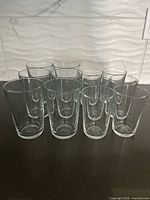 Front view showing twelve clear glass tumblers arranged by size