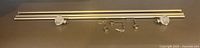 Full view of telescoping metal rod, both glass finials attached, hardware laid out