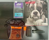 All items together: Woof book, Jumpi boot package, Muttluks treat bag, slicker brush