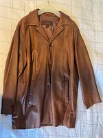 Front view of the brown leather coat on hanger
