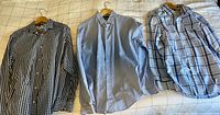 Three shirts laid flat showing patterns and overall condition