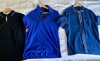 Three shirts laid out on hangers