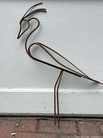 Full view of rusted metal bird garden ornament against white background