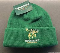 Touque removed from bag showing colour, knit texture, embroidery, tag