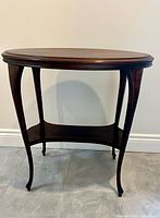 Full view of wood oval table showing legs and lower shelf