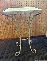 Full view of side table showing metal legs and ceramic top