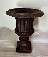 Front view of cast iron urn showing overall design and patina